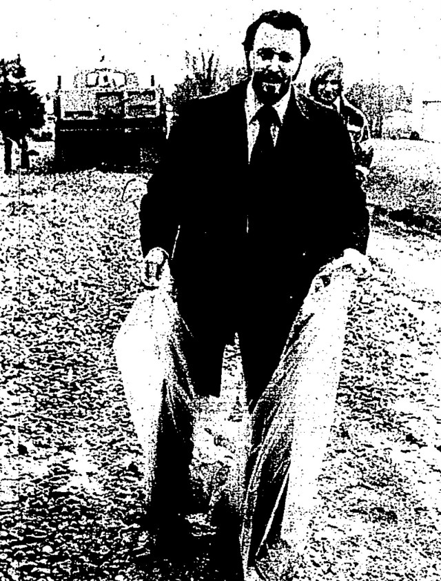 It's up to your knees out there! Music teacher Richard Cardeccia tries to keep his pants clean under a couple plastic trash bags while he hikes through the muck on his way to Power Junior High School on Gill Road.